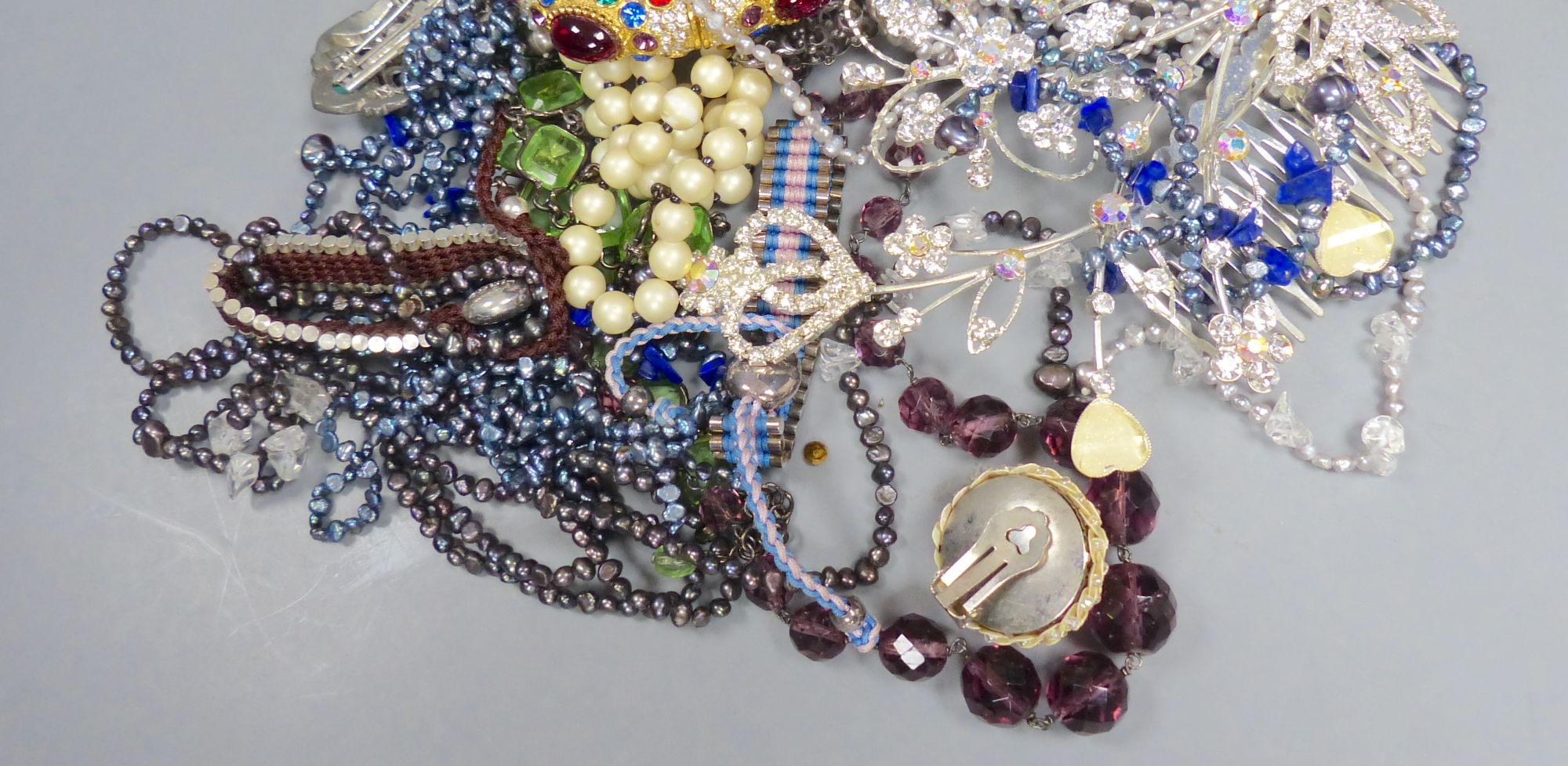 A group of assorted costume jewellery, including coloured paste necklaces.